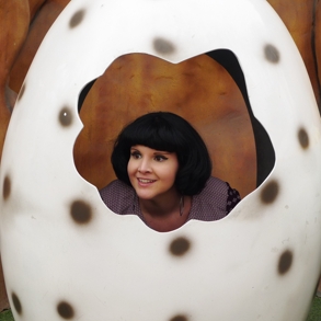Woman posing in an egg sculpture