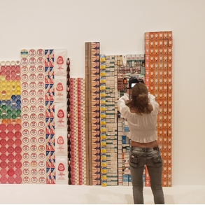 A woman in front of art taking a picture