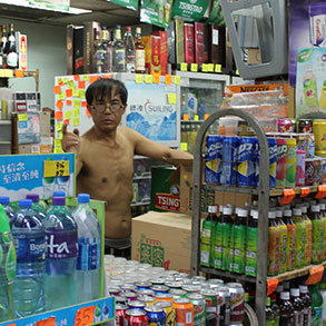 A merchant surrounded by drinks for sale in the Hong Kong heat