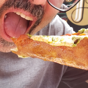 Extreme close-up of a bearded man eating pizza