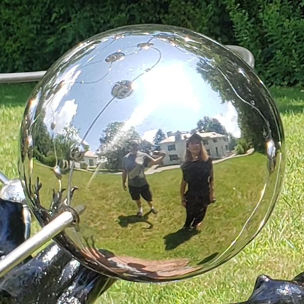 Woman looking at a sculpture with mirror orbs
